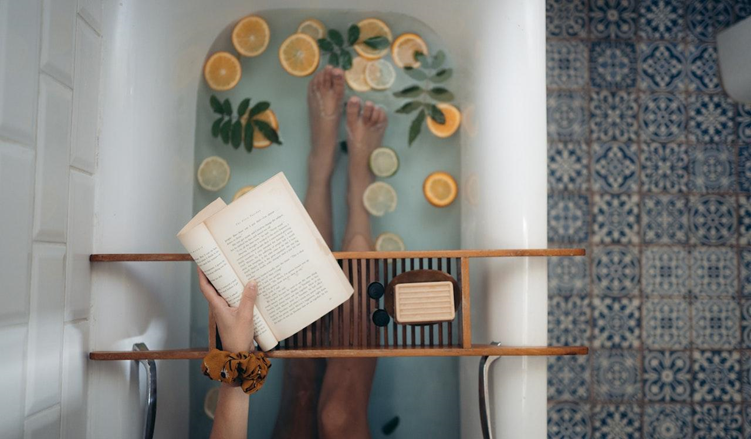 A woman in a hot tub reading a book.